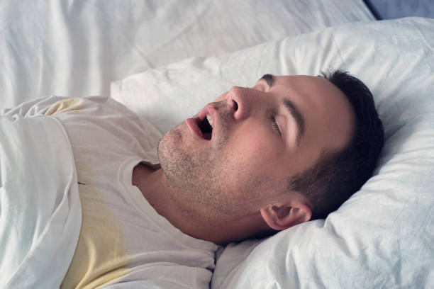 Man sleeping on his back with mouth open, possibly snoring.