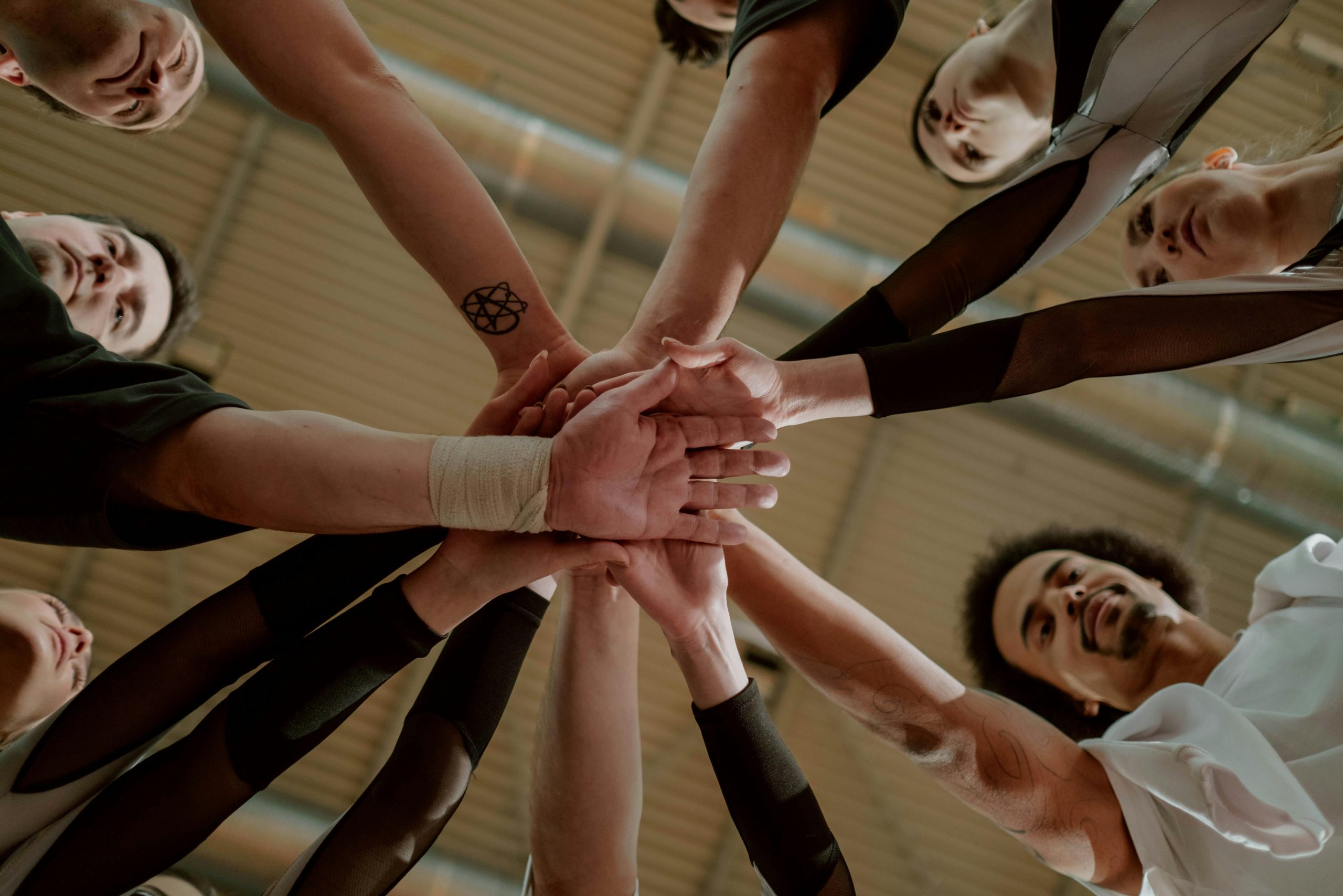 Sleep specialists joining hands in a teamwork huddle.