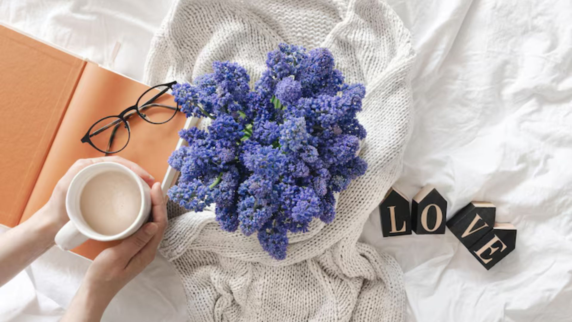 Cozy setting with flowers, coffee, and a book for relaxation.