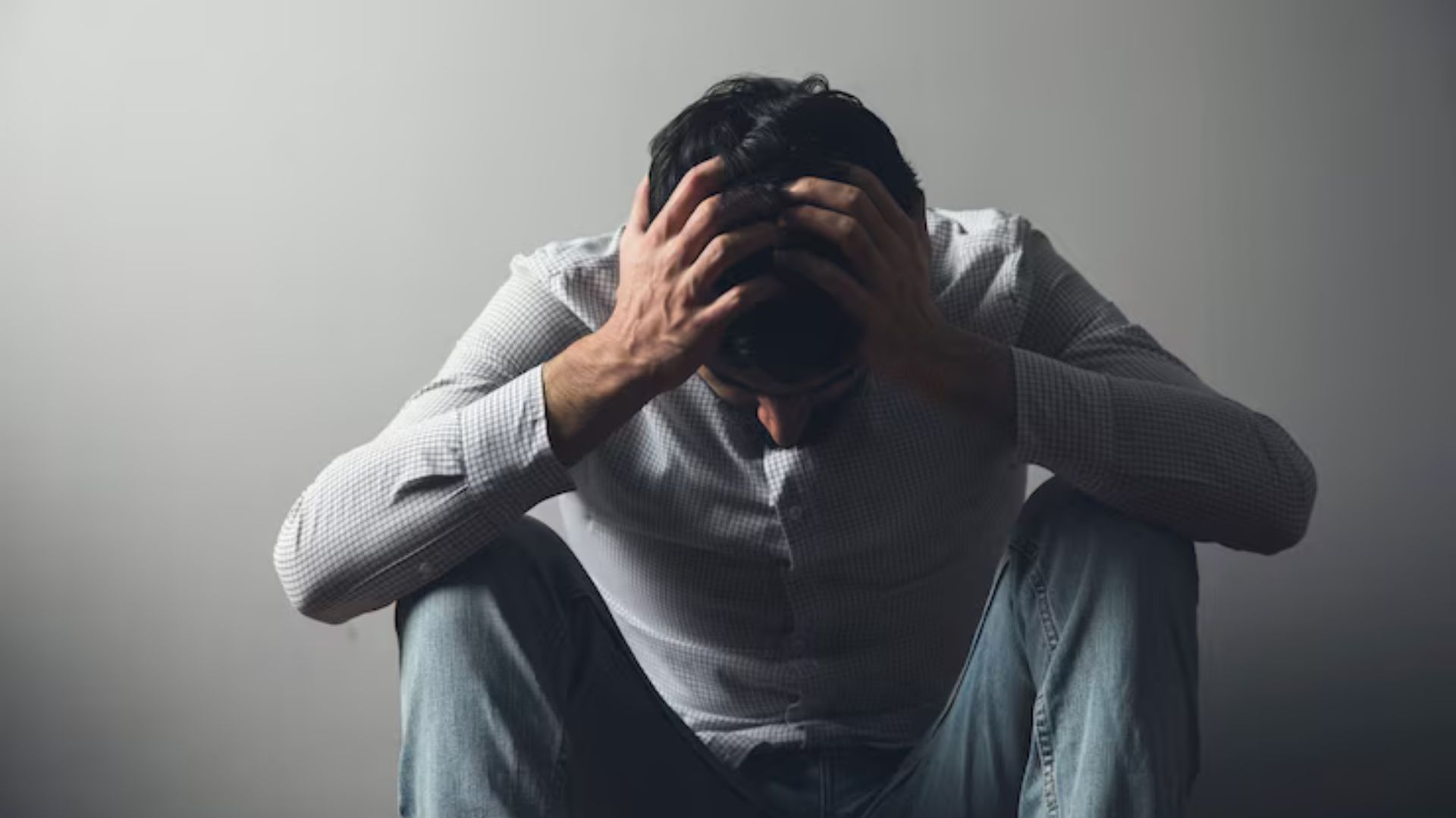 Man holding his head in distress, illustrating anxiety and stress.