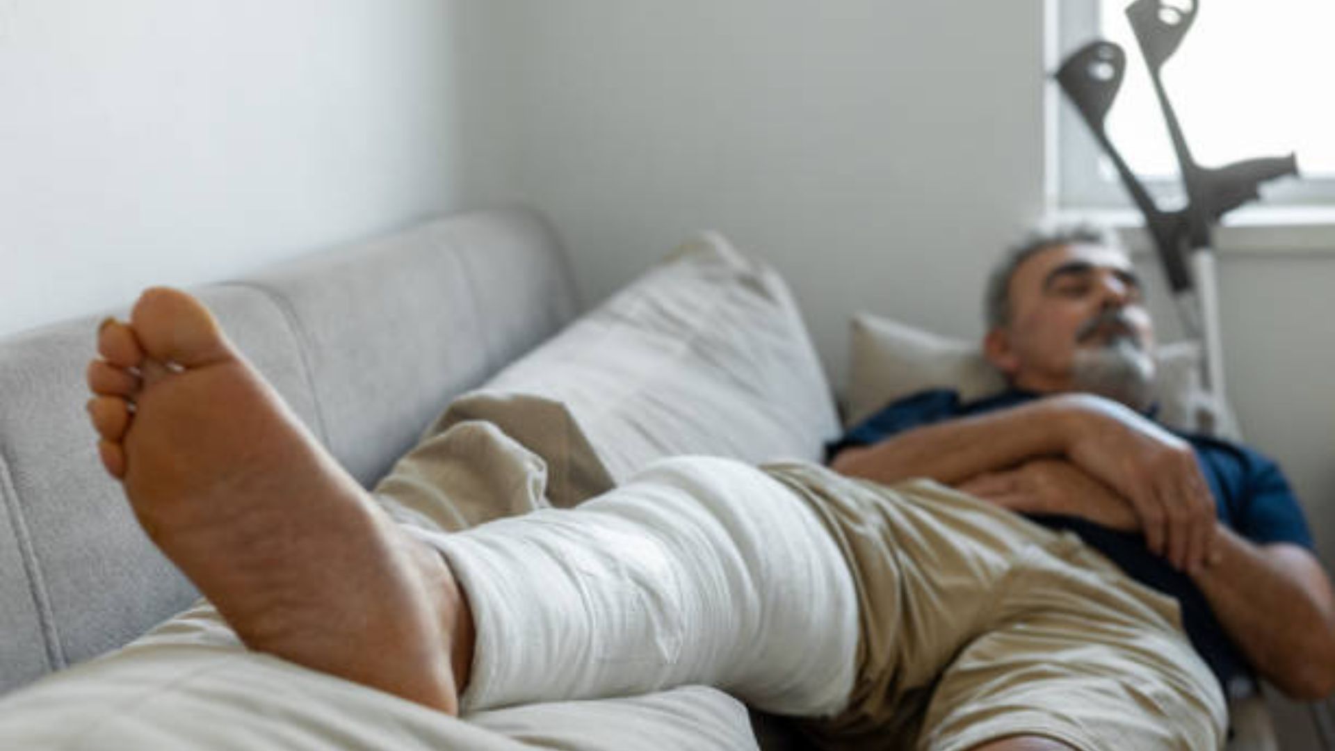 Man resting with a bandaged leg, emphasizing recovery.