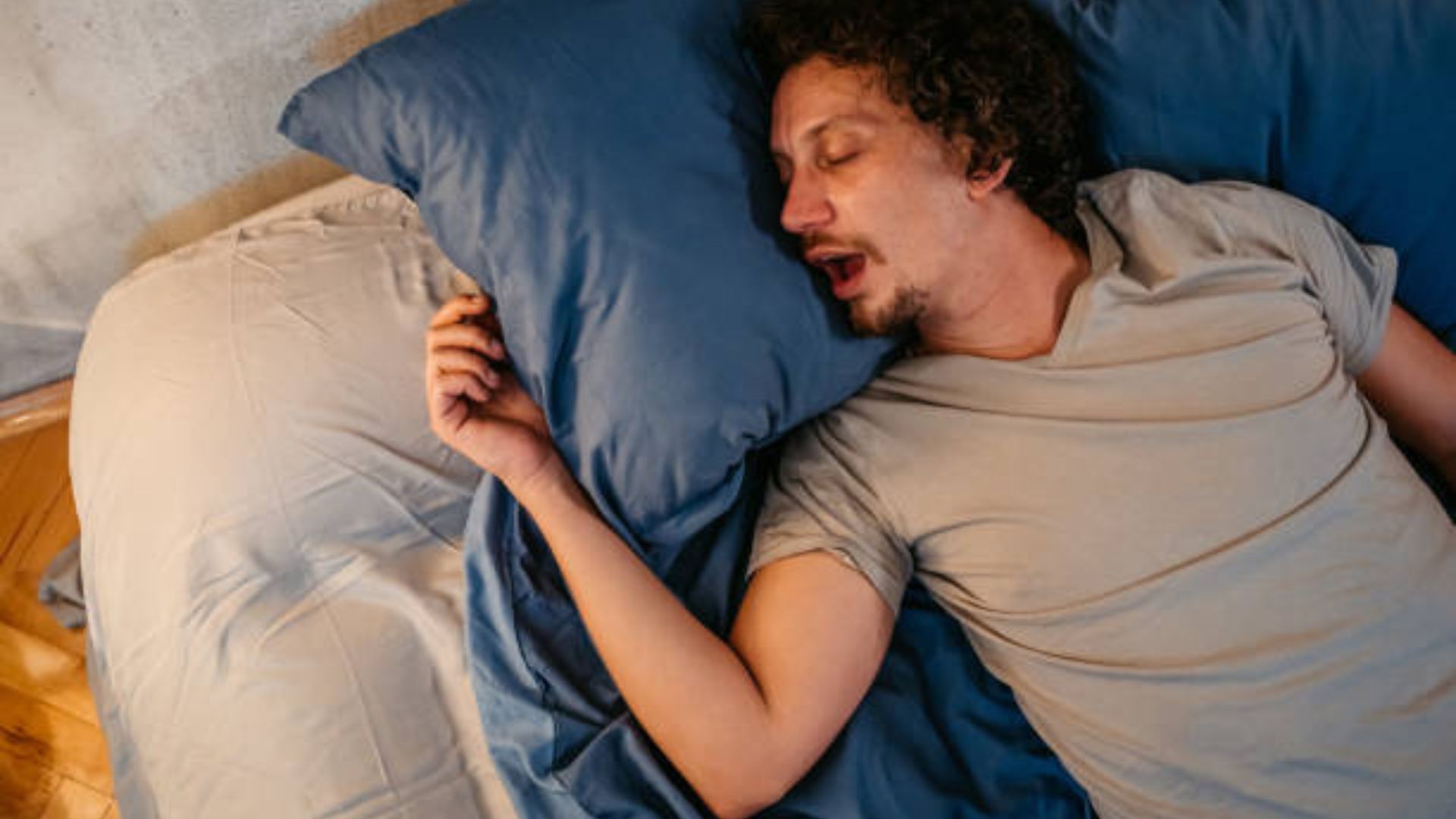 Man experiencing sleep apnea while resting in bed.