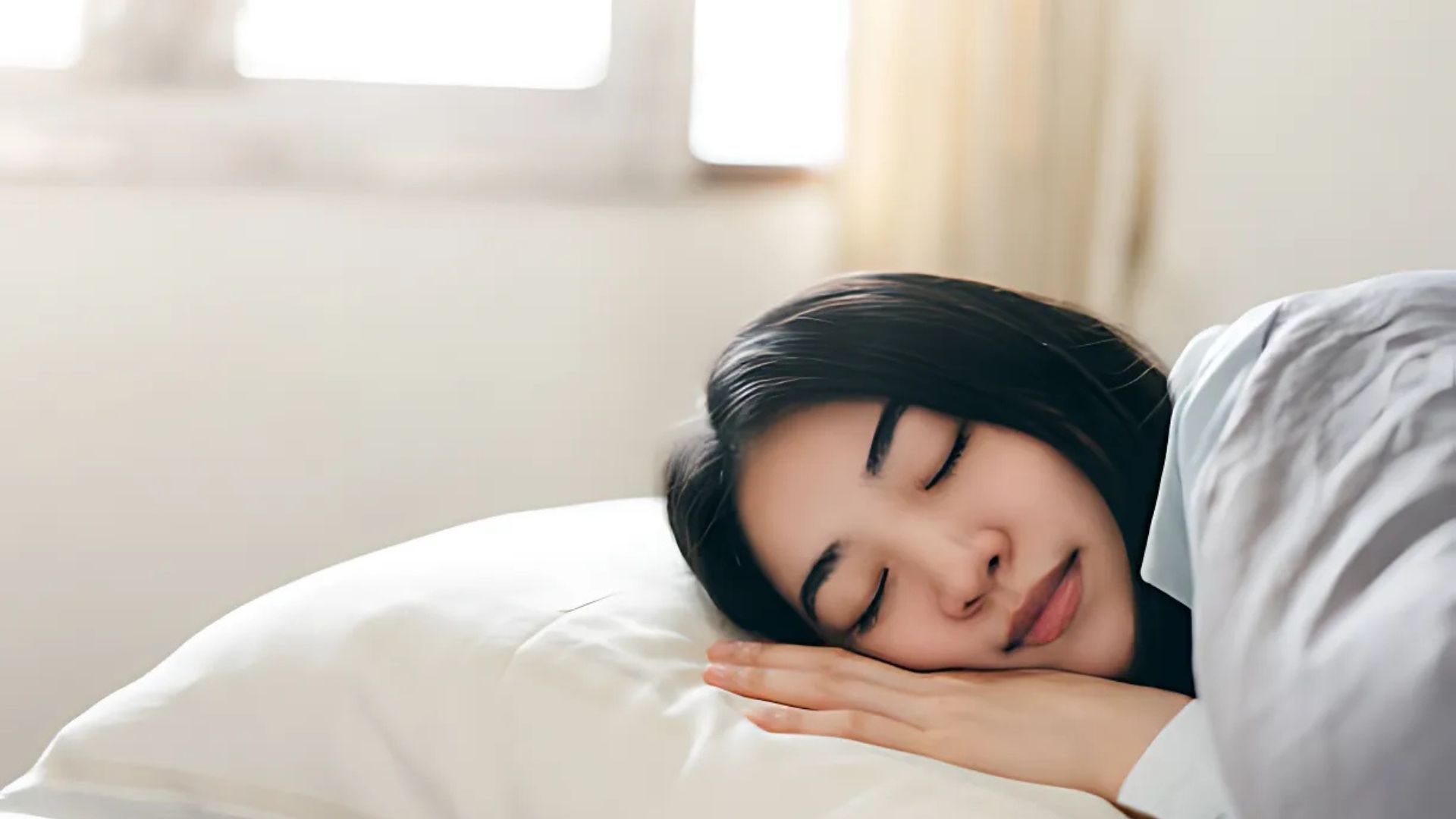 A woman peacefully sleeping with a relaxed expression in bed.
