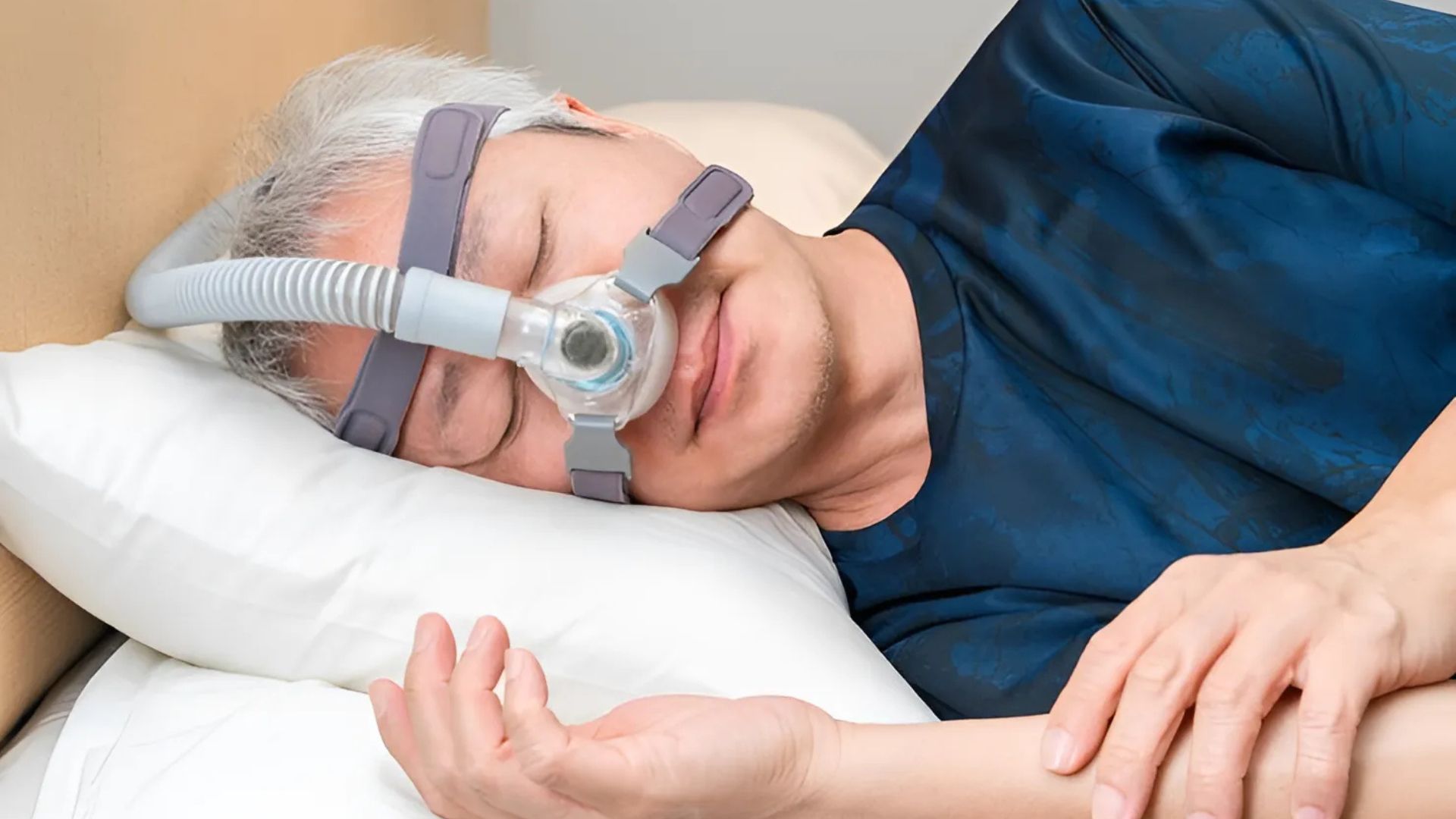 Man using CPAP therapy mask while sleeping to prevent snoring.
