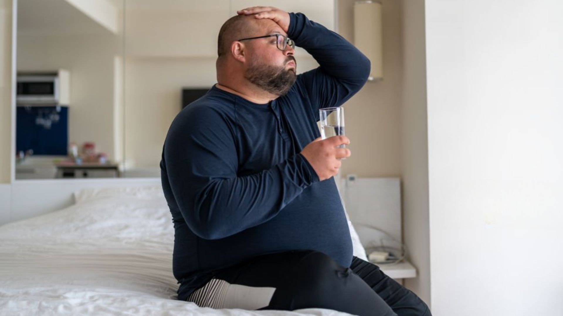 Man holding head with morning headache sleep apnea symptom