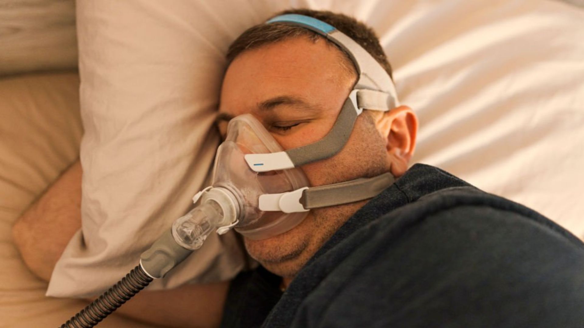 Man sleeping with CPAP mask for obstructive sleep apnea
