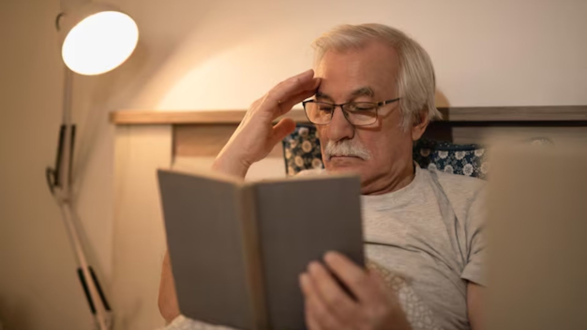 Older man reading before bed as part of a nightly routine.