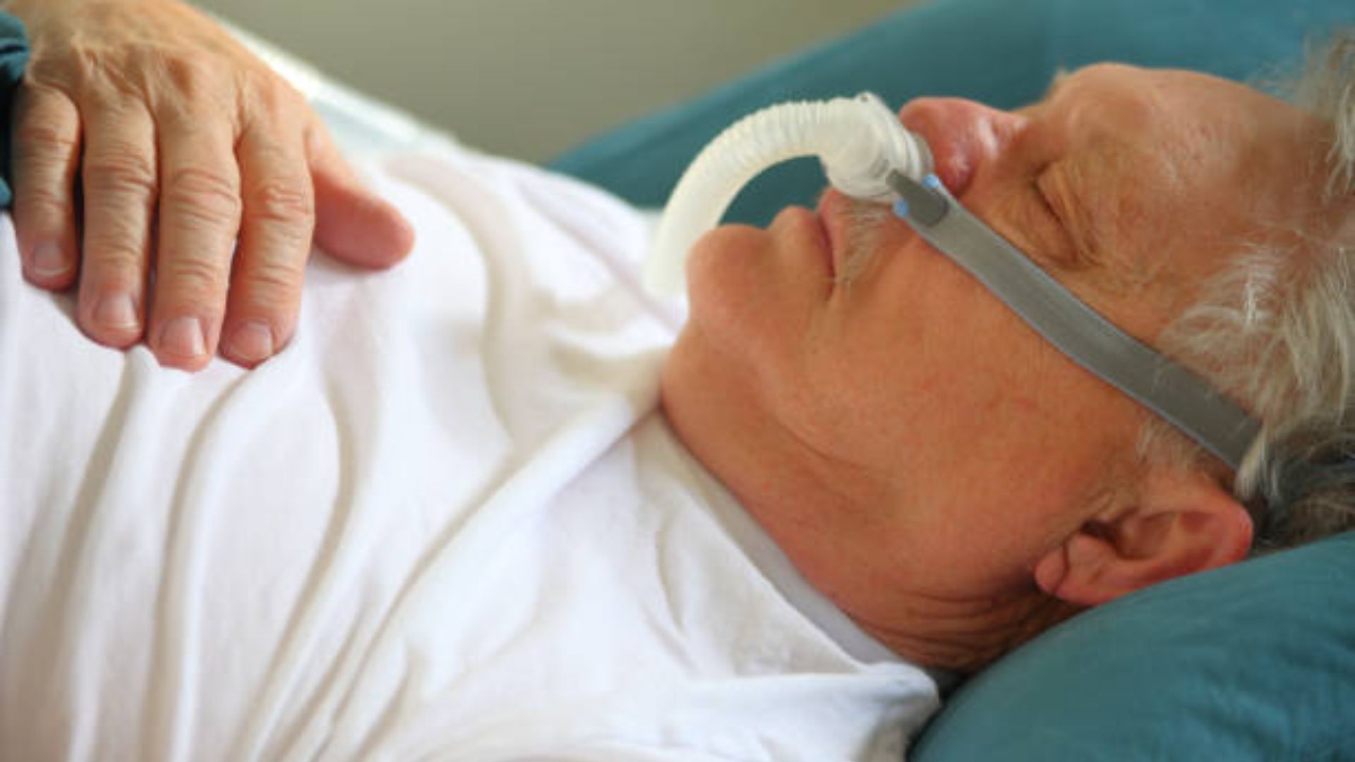 Man sleeping with CPAP machine during a regular sleep time.