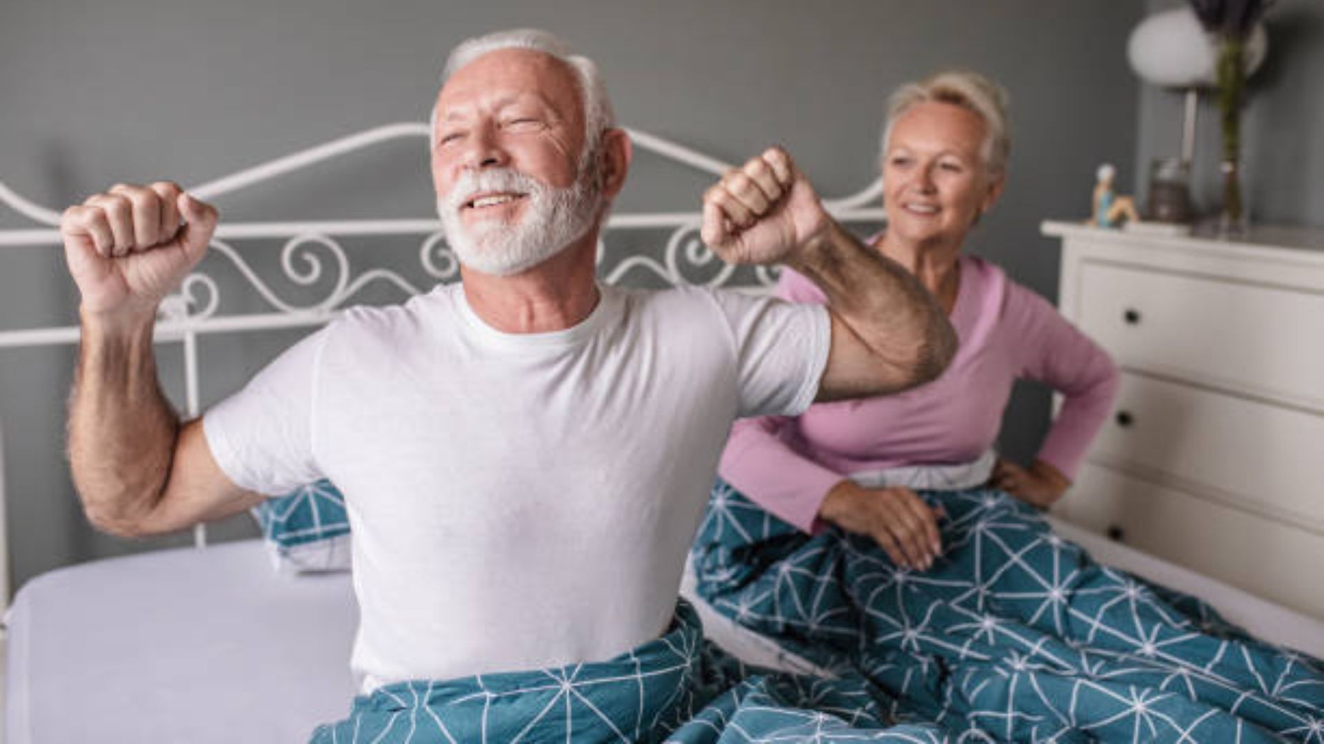 Older couple waking up happy at the same time each morning.