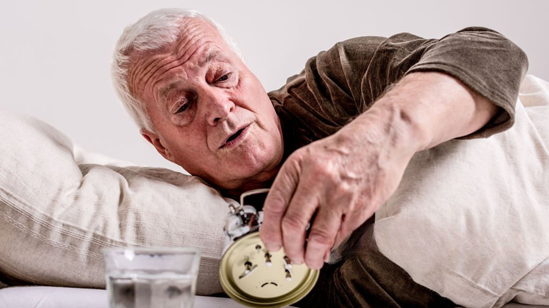 Senior checking time before taking a daytime nap
