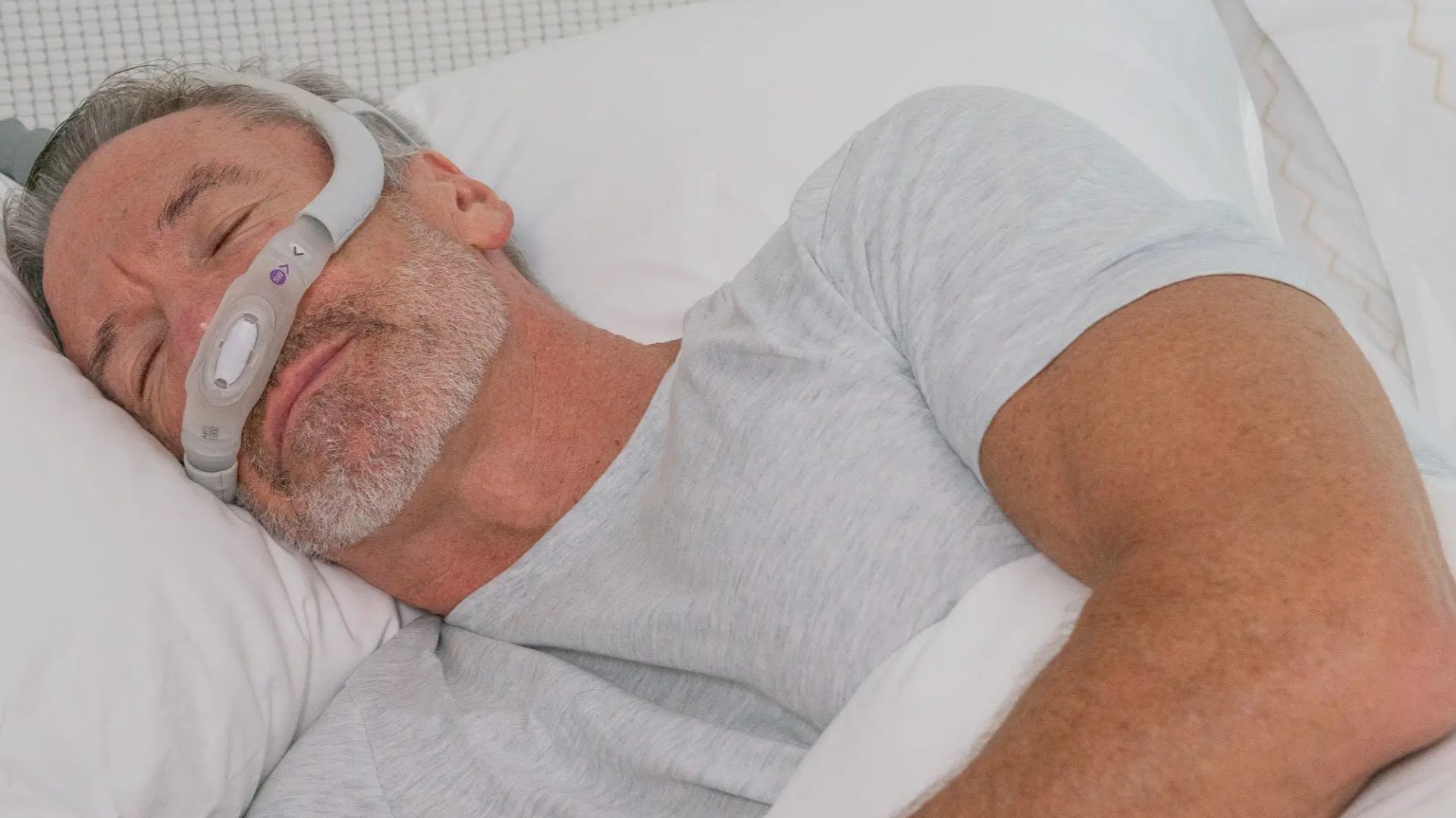 Man sleeping with CPAP mask showing sleep apnea signs