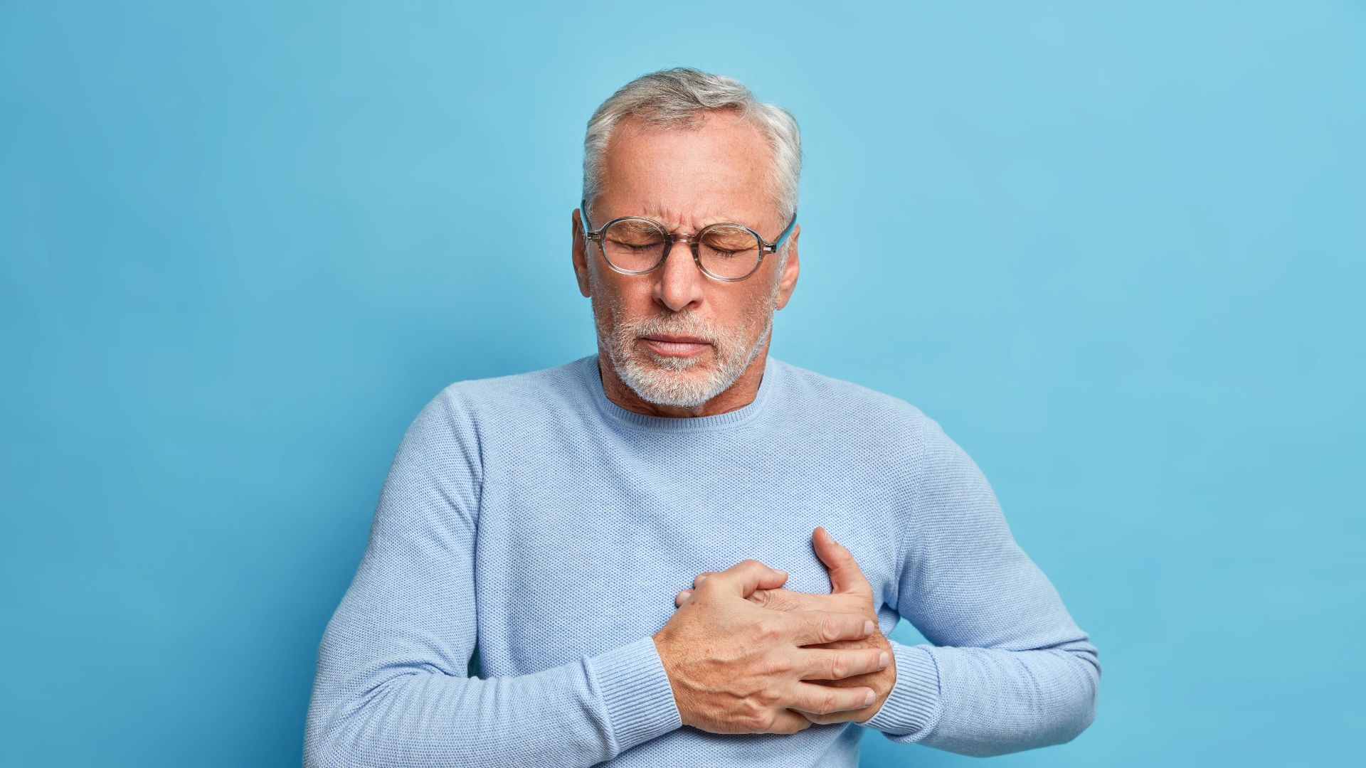 Man holding chest showing heart risk from untreated sleep apnea