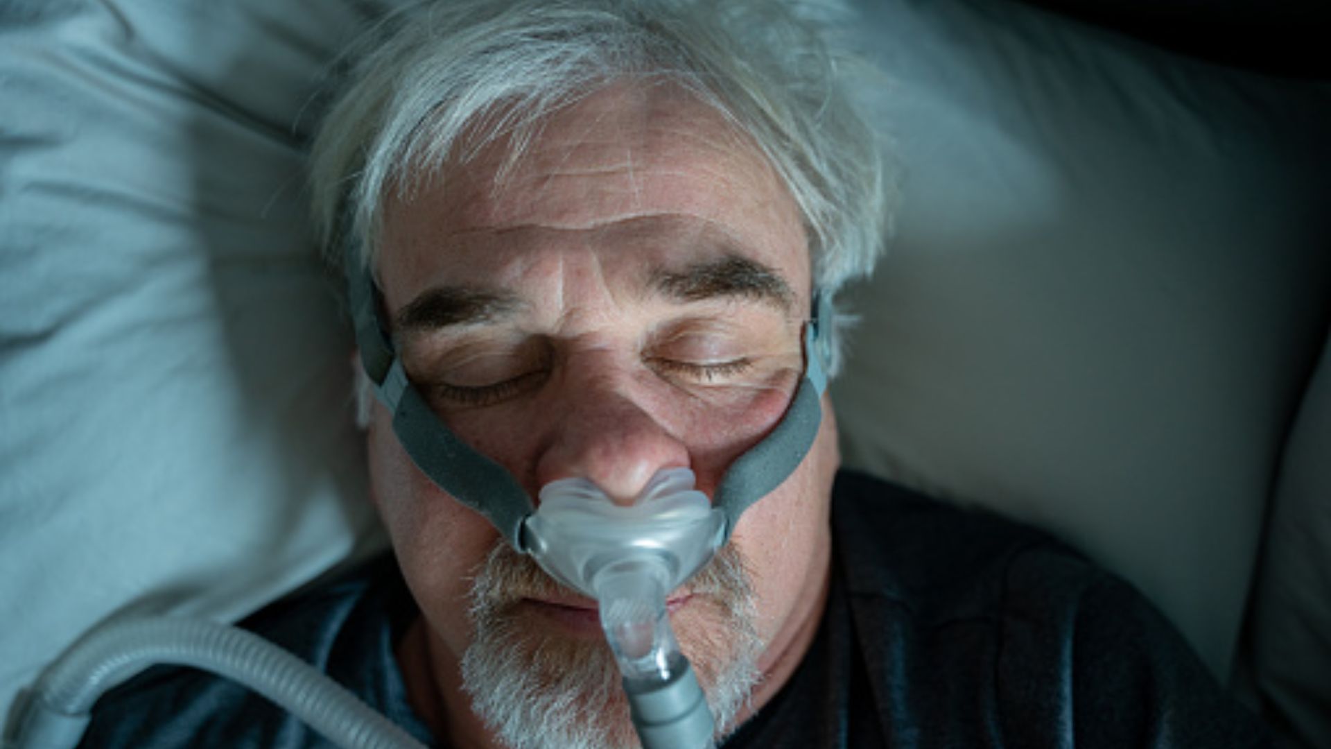 Man sleeping with CPAP therapy for sleep apnea treatment