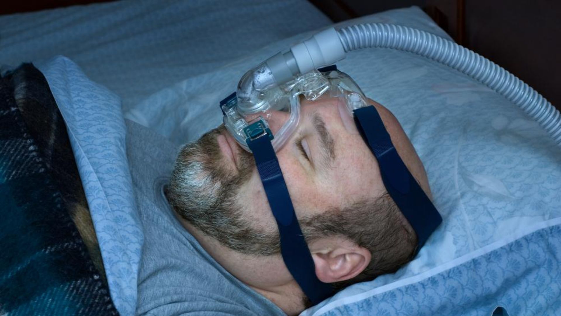 Man sleeping with CPAP therapy for sleep apnea treatment